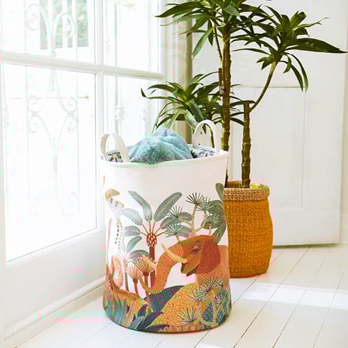 Close-up of Karina Jambrak x Adairs Kids Storage Basket with plant in the background. 