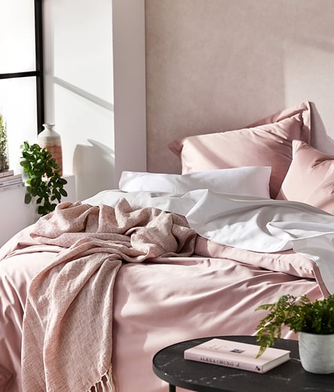 bed with pink bamboo cotton set sheet and pillows
