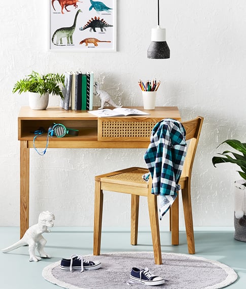 Adairs Kids Arden Rattan Natural Desk and matching chair against wall. 