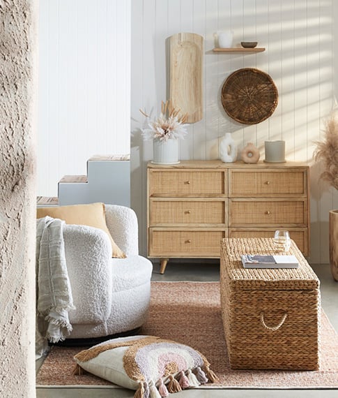 Coastal inspired living room with boucle chair, rattan chest as a coffee table and Anjuna Chests of drawers at the back. 