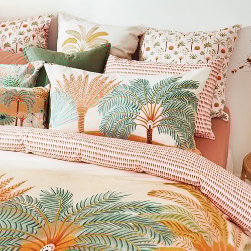 Karina Jambrak x Adairs Printed Bedlinen with palm trees in green and warm terracotta hues, styled with matching accessories.