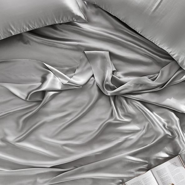 close up of silver silk sheet and matching pillow
