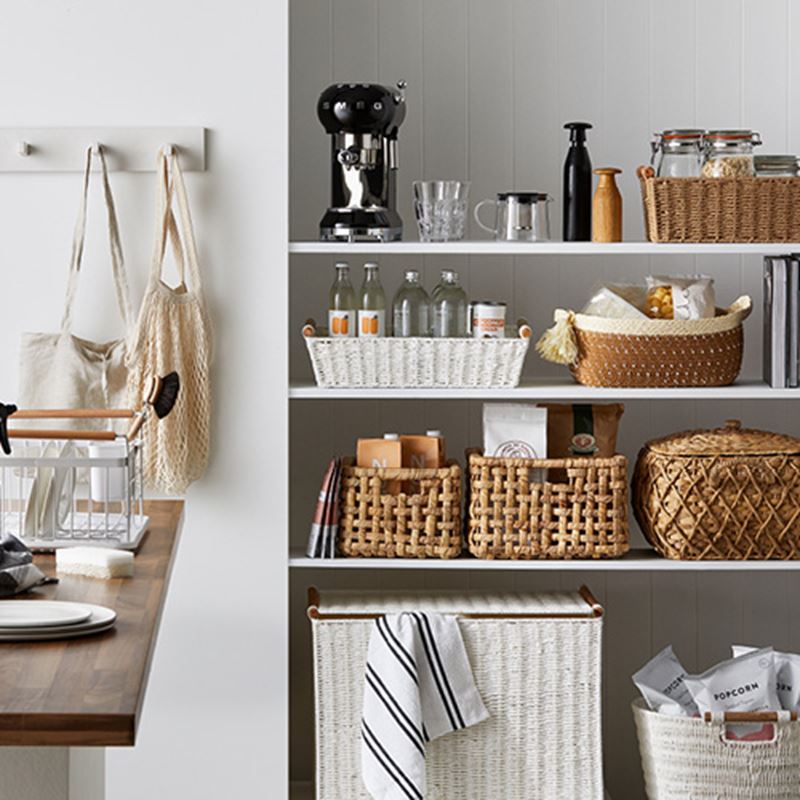 four shelf pantry with a range of products in storage trays and baskets