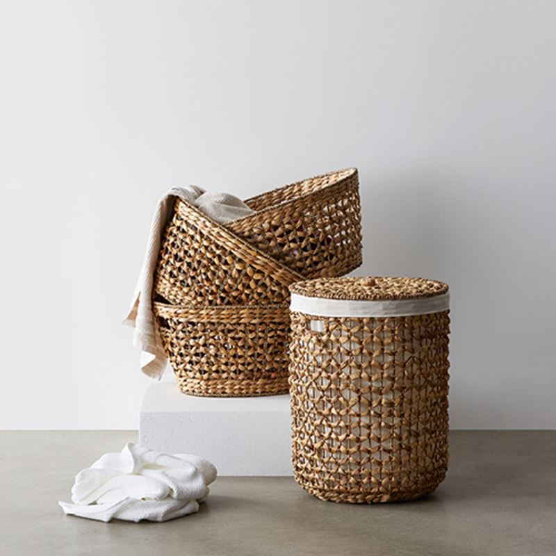 Various brown straw baskets with towel inside and on the floor