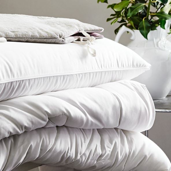 White minijumbuk pillow stacked on top of a matching mattress topper