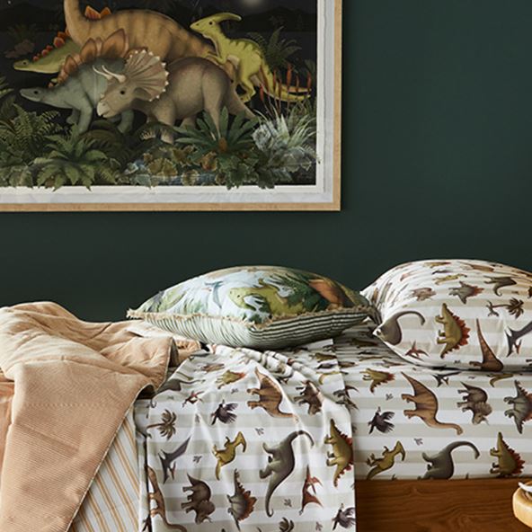 Side-on view of the Fleur Harris Prehistorica Combo Sheet Set with matching wall art in the background. 