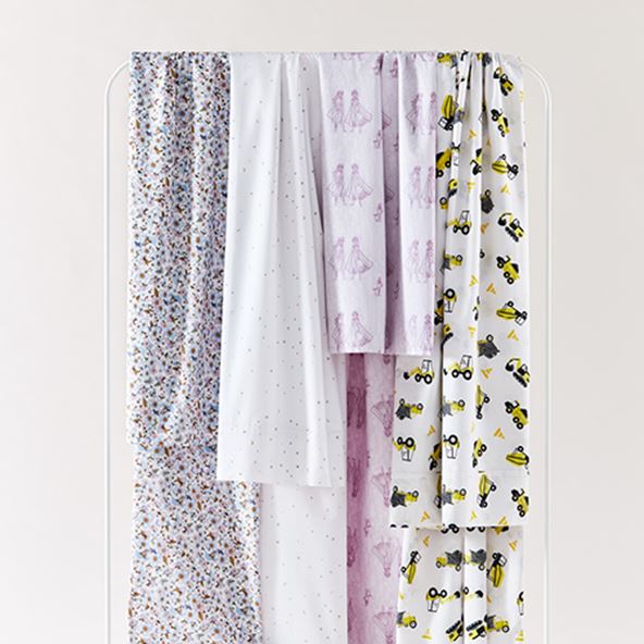 kids nursery set of various printed sheets hanging from a rack