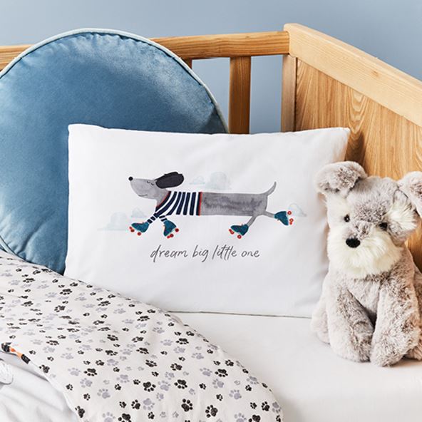 kids pillow case in a cot next to grey dog soft toy