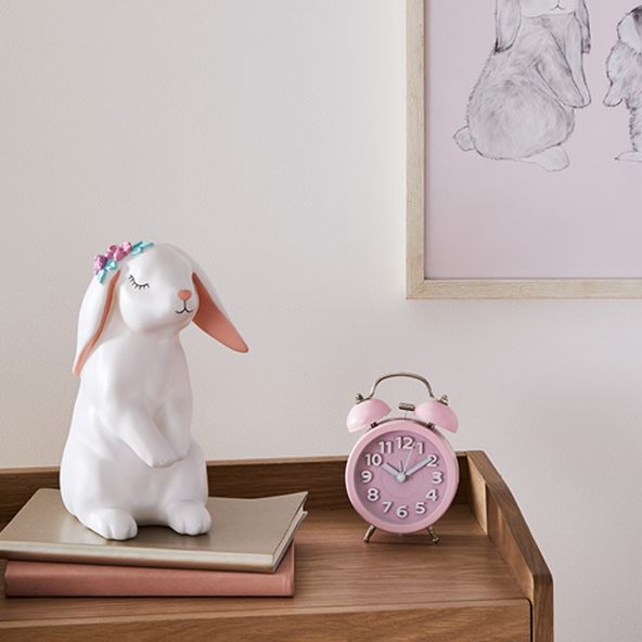 kids room with a pink clock and white night light rabbit