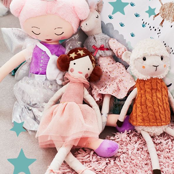 A collection of plush toys including a lamb, ballerina, horse, and fairy sitting together on top of a pink rug. 