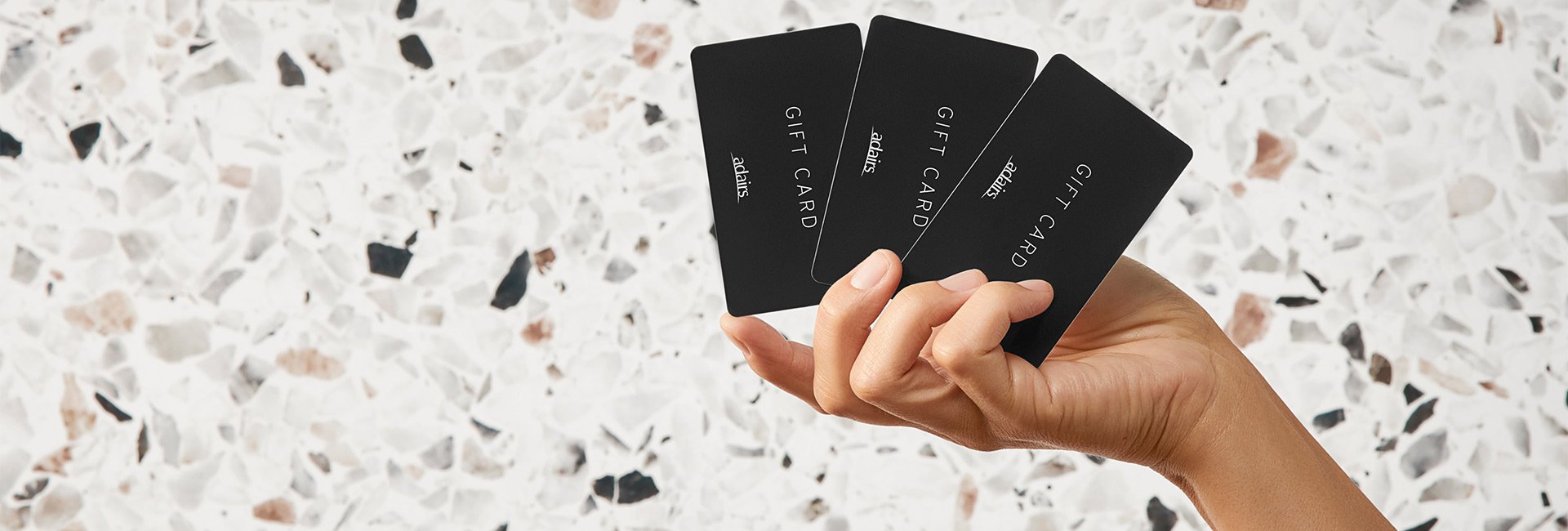 hand holding black gift cards